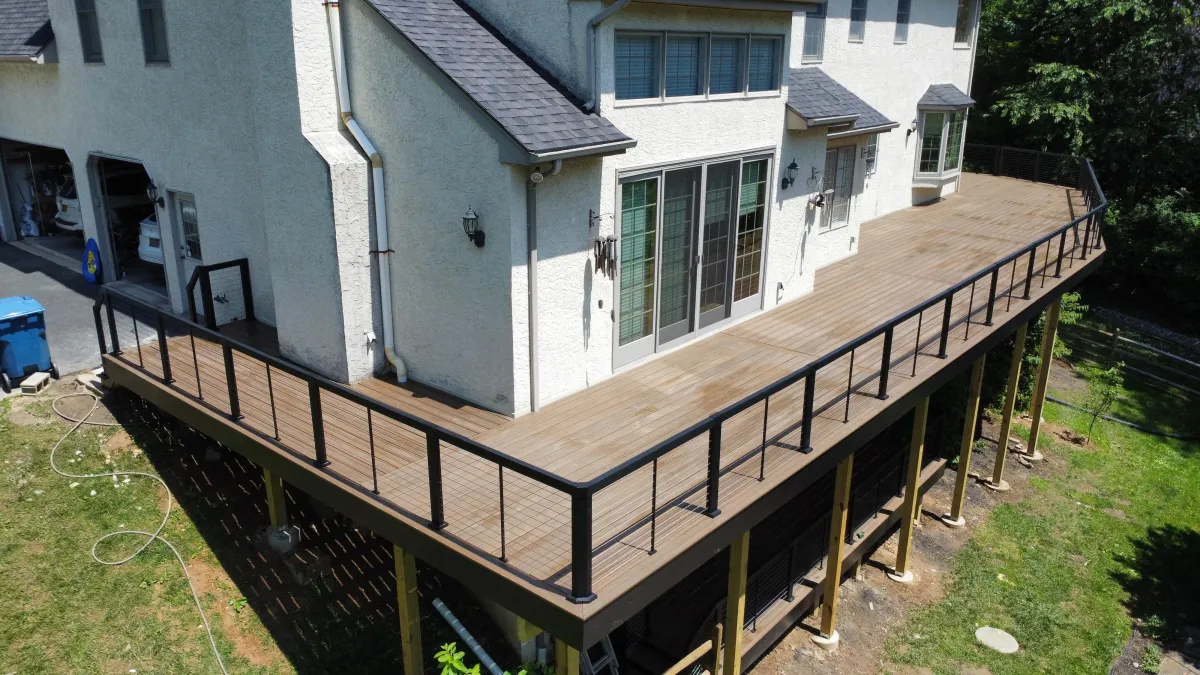 Long brown composite deck with black railings on a white stucco home | Prime Decks Delaware, serving North Star, DE