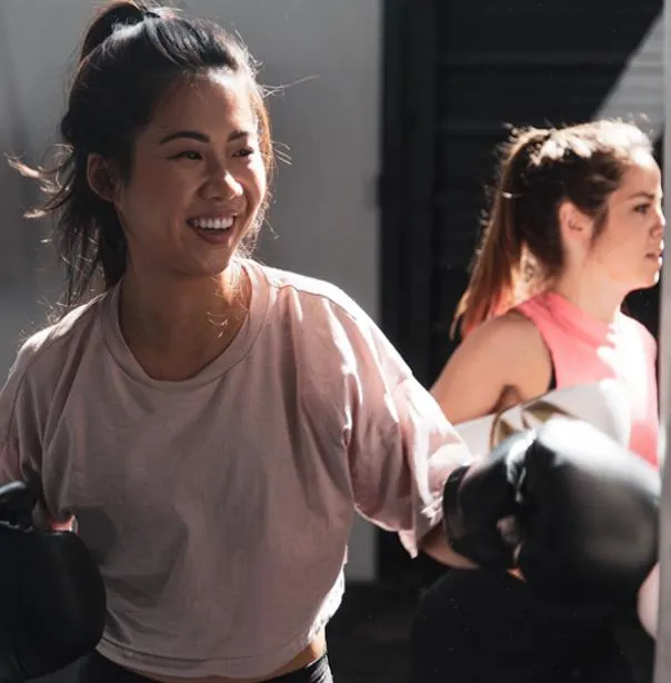 Woman training with boxing gloves, symbolizing strength, resilience, and personal motivation
