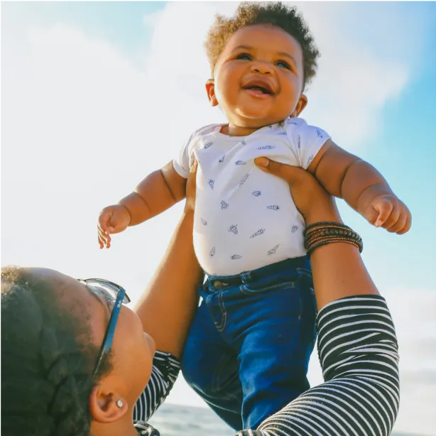 adult holding baby in the air