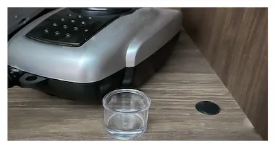 small clear bowl with water near a fish aquarium air pump