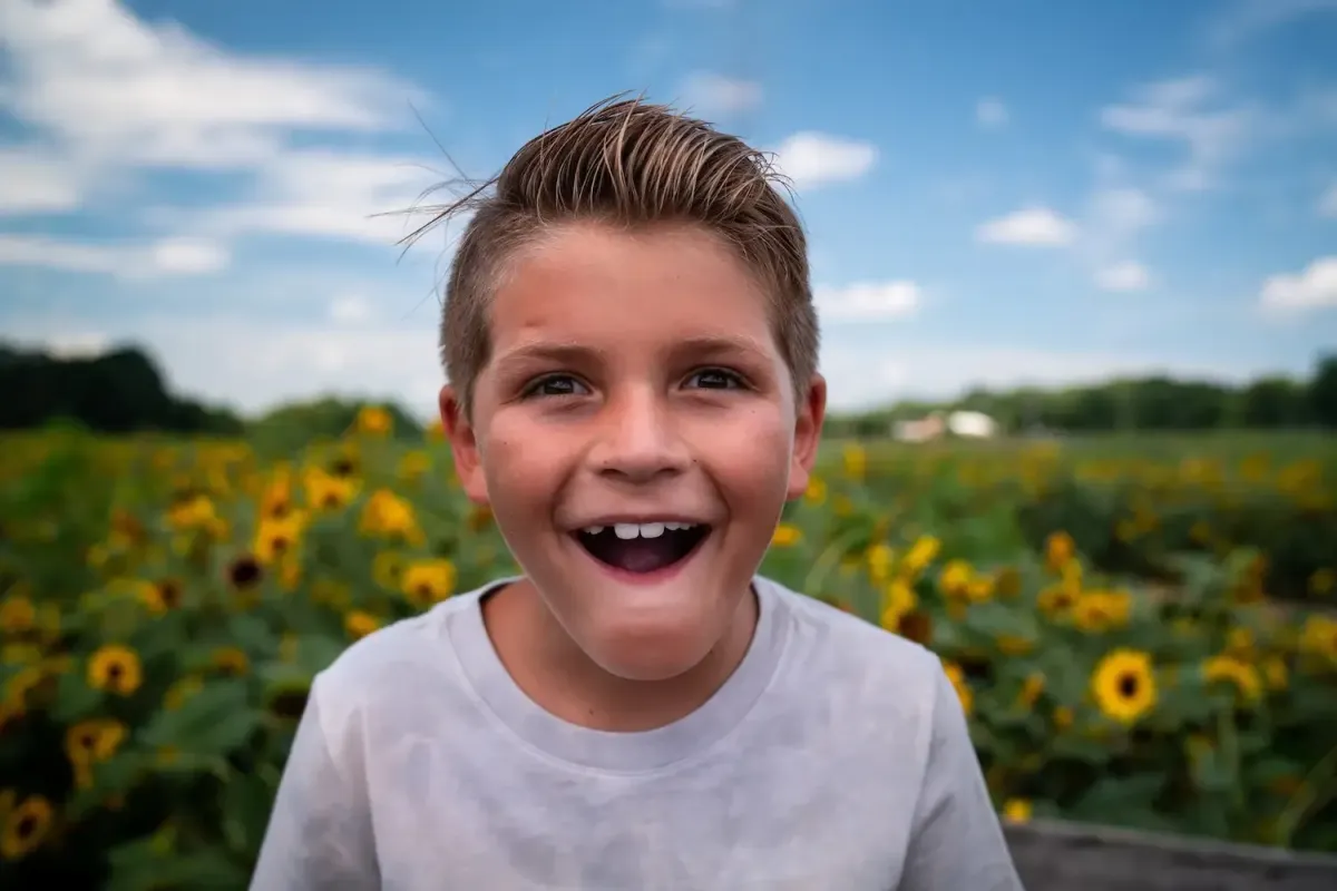 boy with a surprised look on his face in a sunflower field