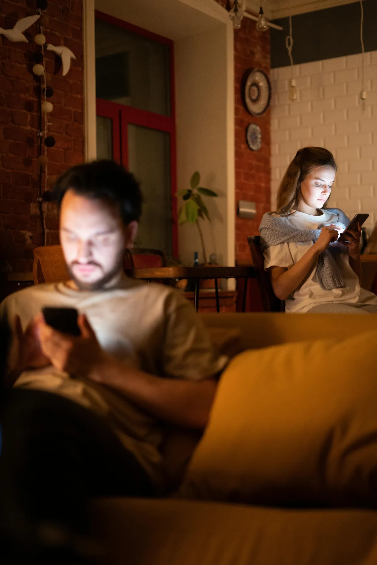 Man and woman together, looking intently at their phones