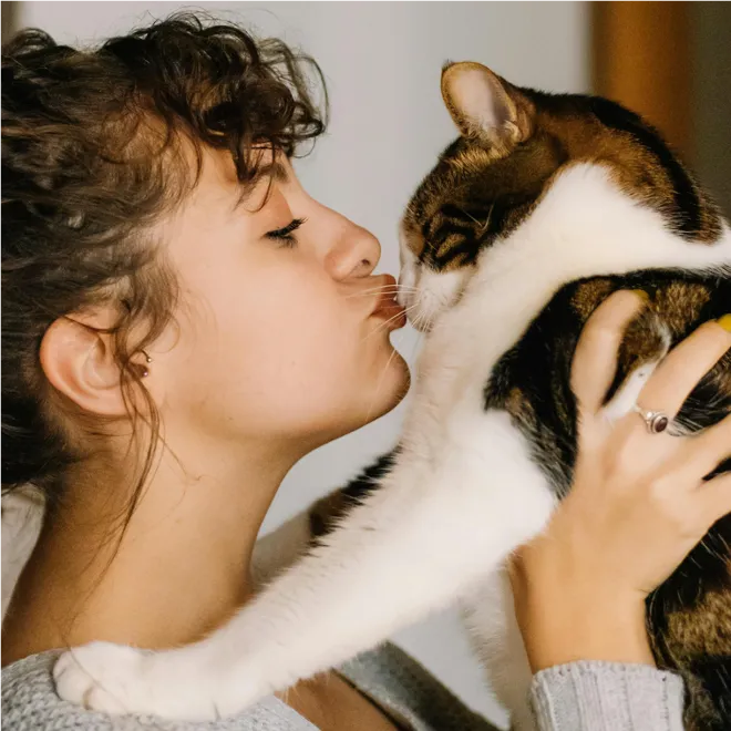 woman kissing a cat