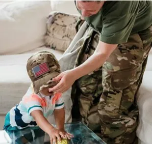 Represents a military parent comforting a child in an on-base home setting where Calm Work Solutions has been lightly misted.