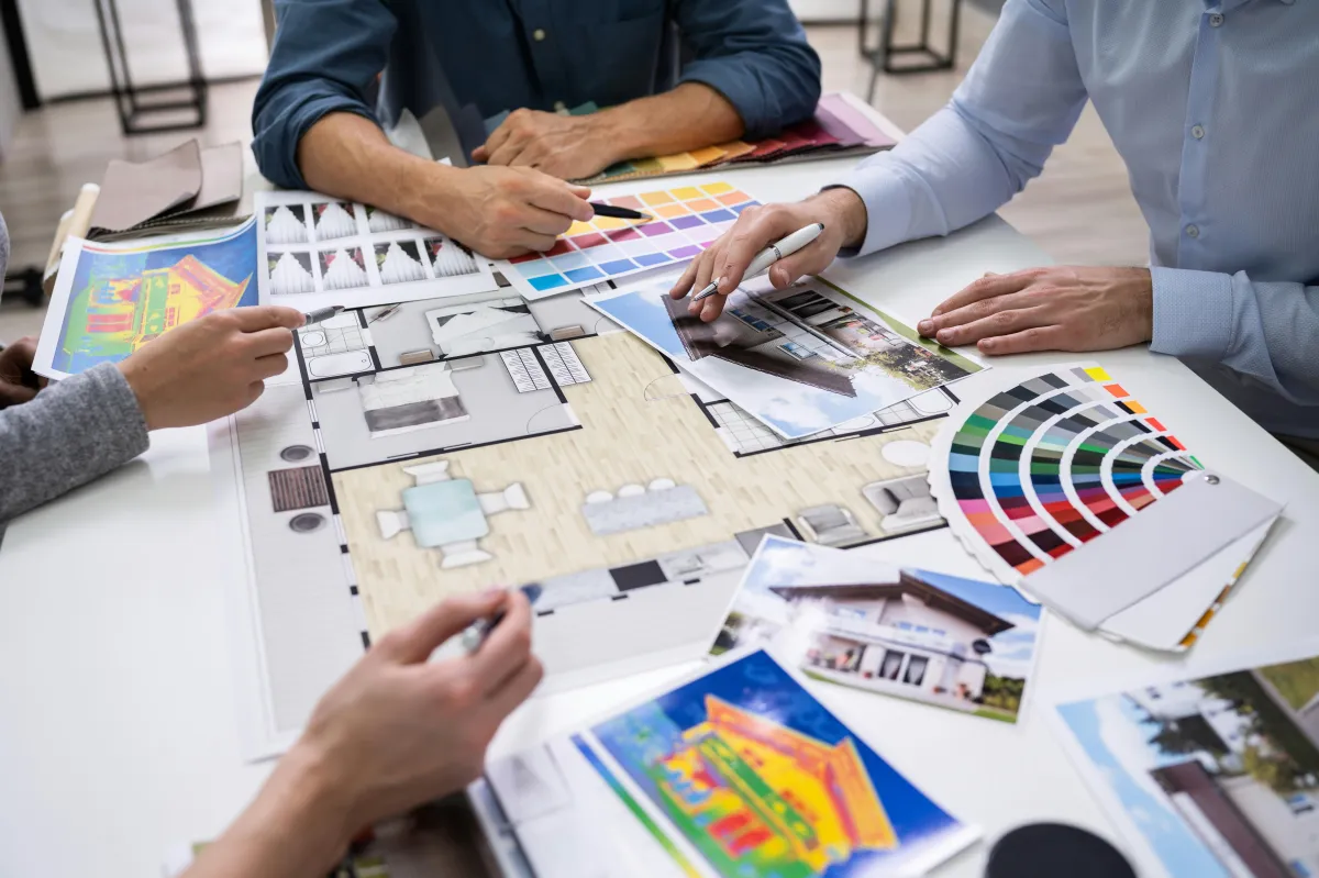 four people around a conference room table looking at plans for a home