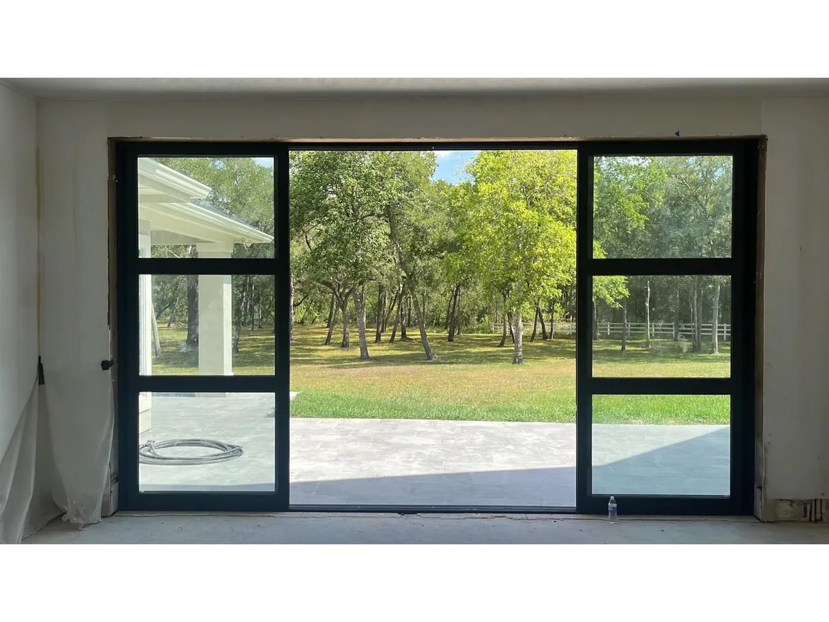 Black-framed glass patio doors opening to a backyard
