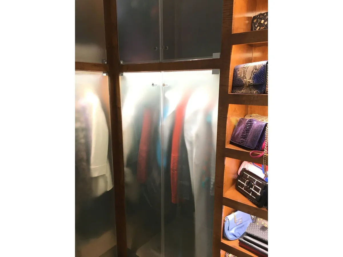 Custom closet with frosted glass doors and glass shelves