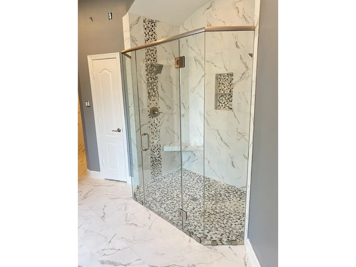 Frameless glass shower enclosure with marble tile in Houston