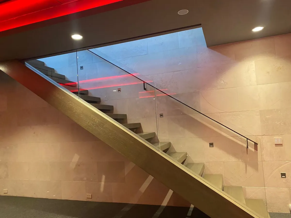 Glass staircase railing with modern lighting