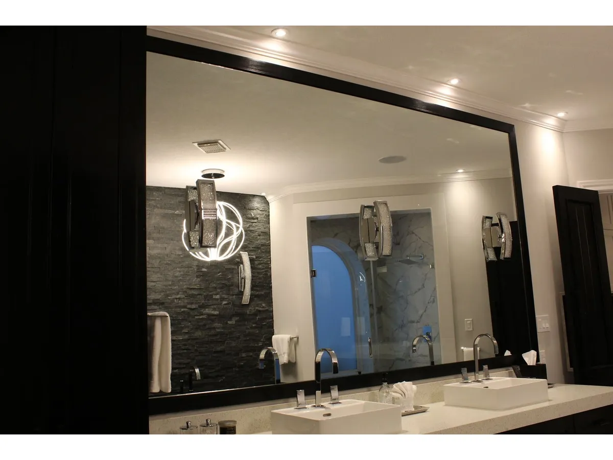 Large custom framed mirror above a double vanity in Houston