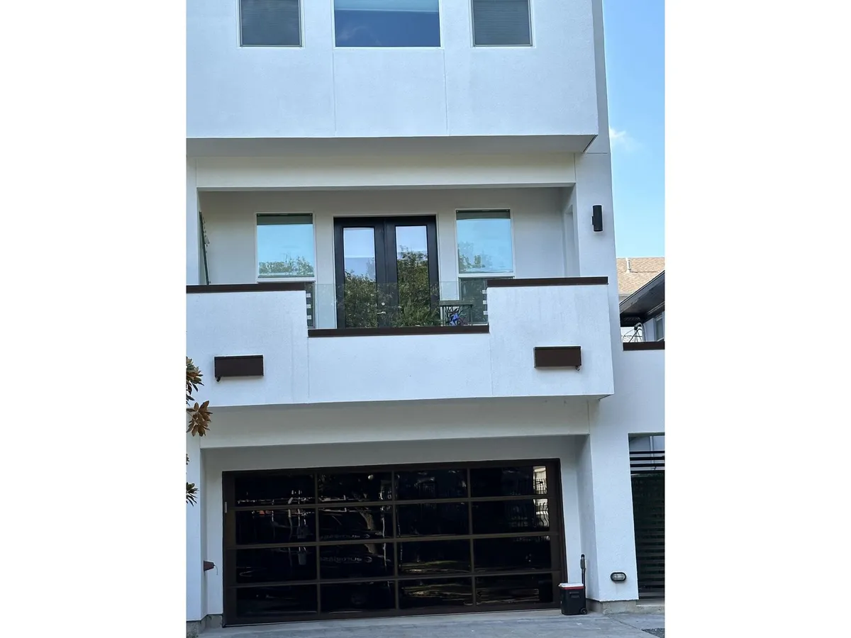 Modern home with glass balcony railings and garage