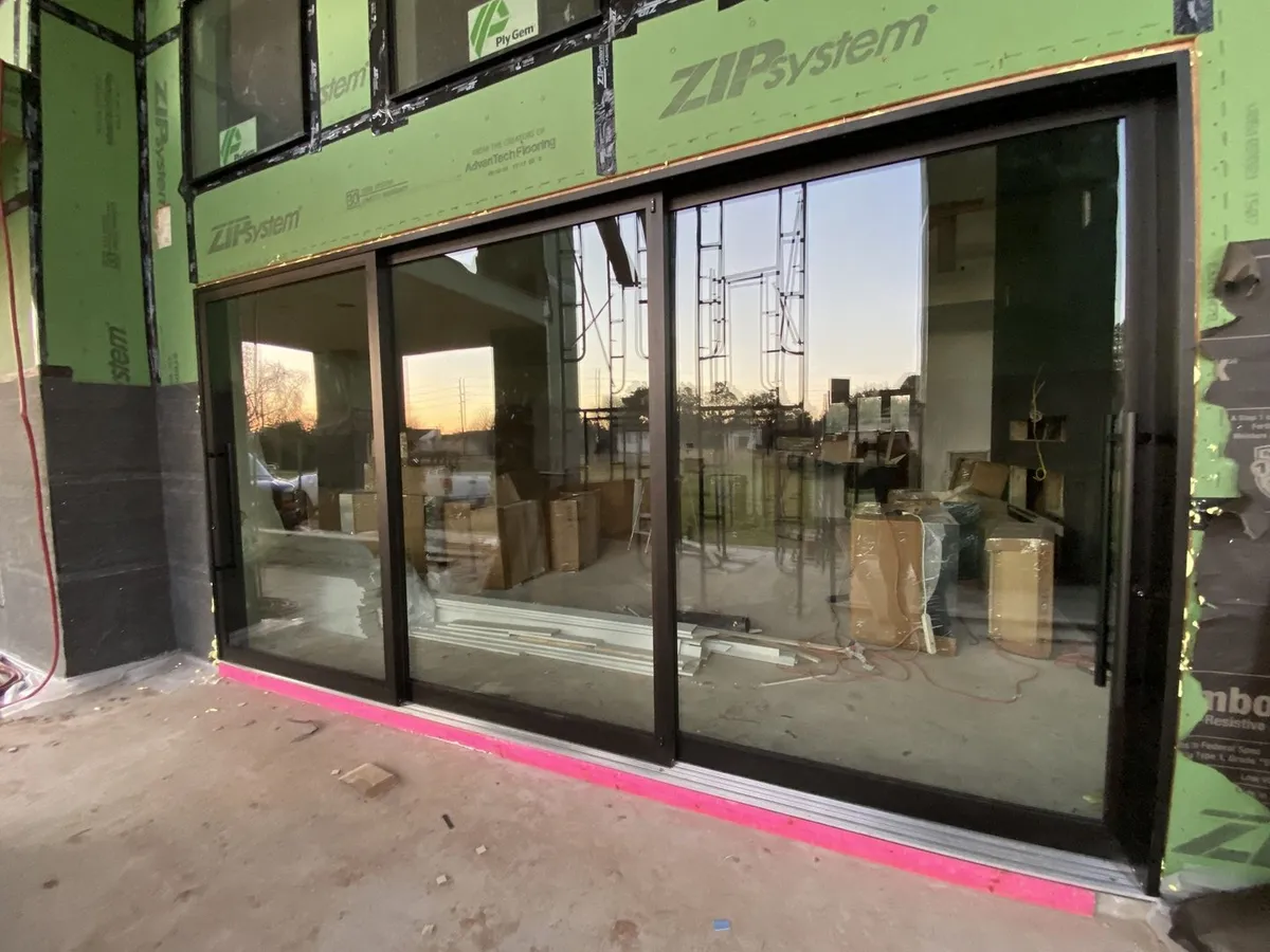 New black sliding glass door installed in new construction