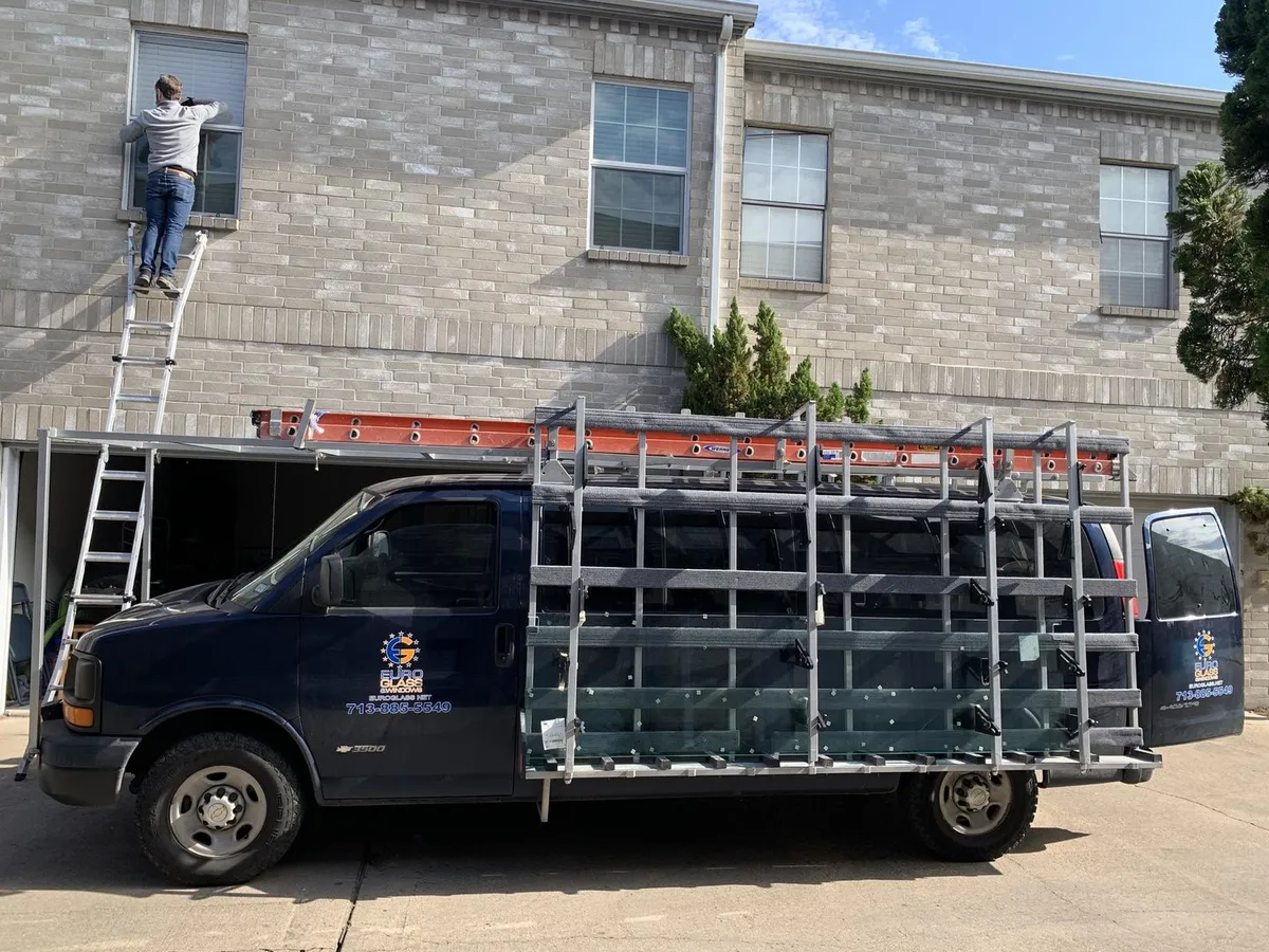 Technician on a ladder beside the Euro Glass van with glass