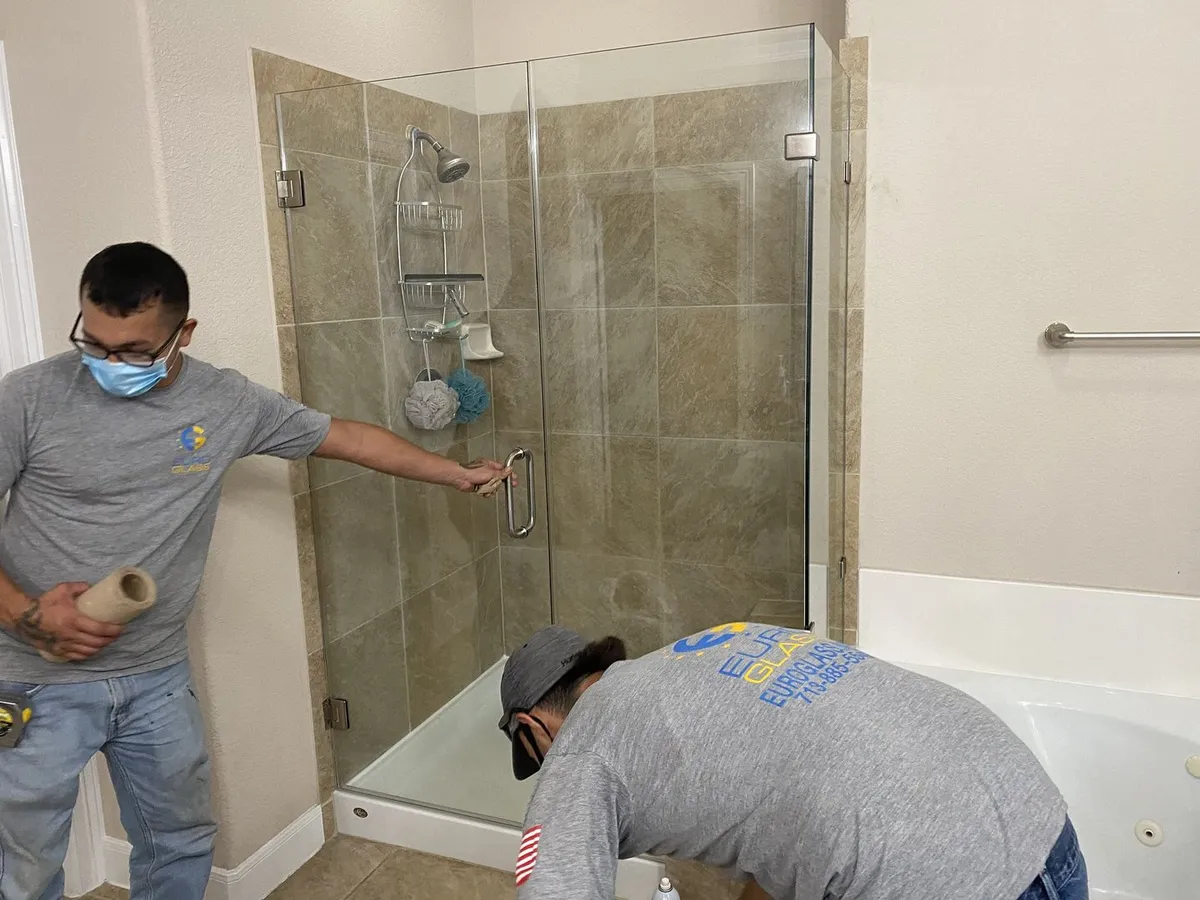 Two Euro Glass technicians installing a frameless shower enclosure