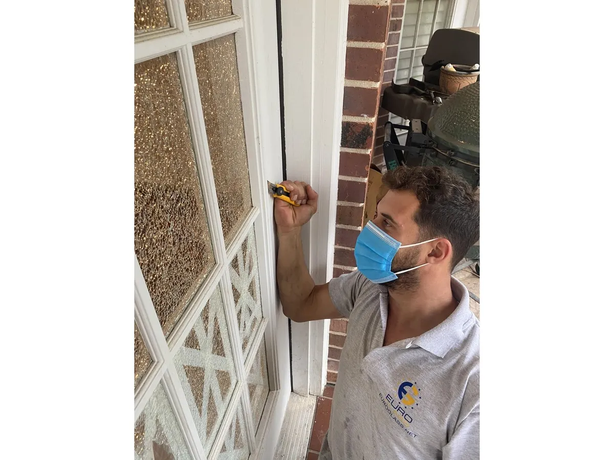 Technician replacing glass in a decorative window