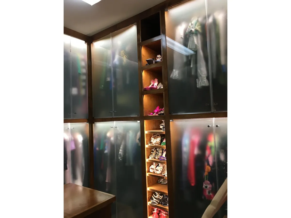 Walk-in closet with glass shelving