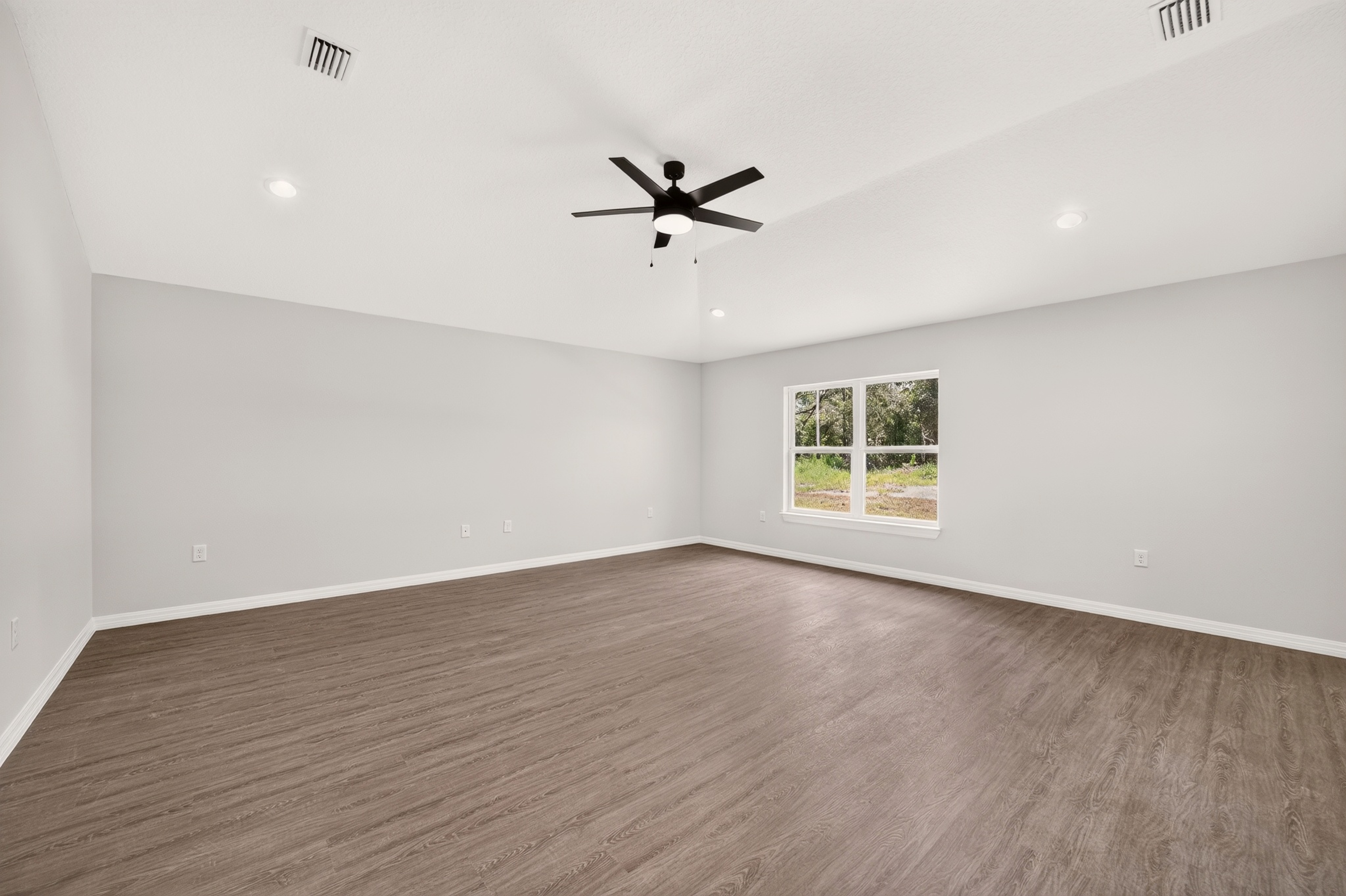 Spacious master bedroom suite with natural light and ceiling fan in the Timberland model home