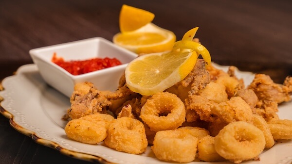 Fried calamari with a lemon garnish on top