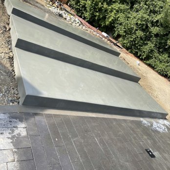 Covered outdoor kitchen with stainless appliances and lighting by Mundo Landscaping Tucson, AZ — custom backyard entertainment space.