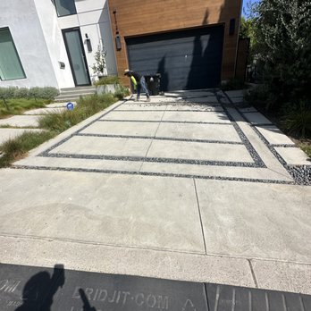 Stone retaining wall and driveway in front of a luxury home built by Mundo Landscaping in Tucson, AZ — expert hardscaping and curb appeal design.