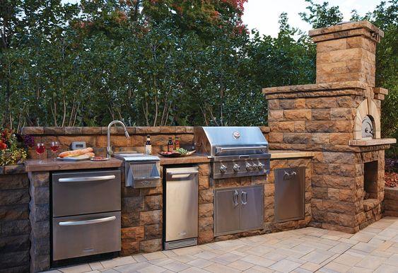 Outdoor kitchen with stone BBQ island and built-in grill by Mundo Landscaping in Tucson, AZ — durable and stylish backyard design.