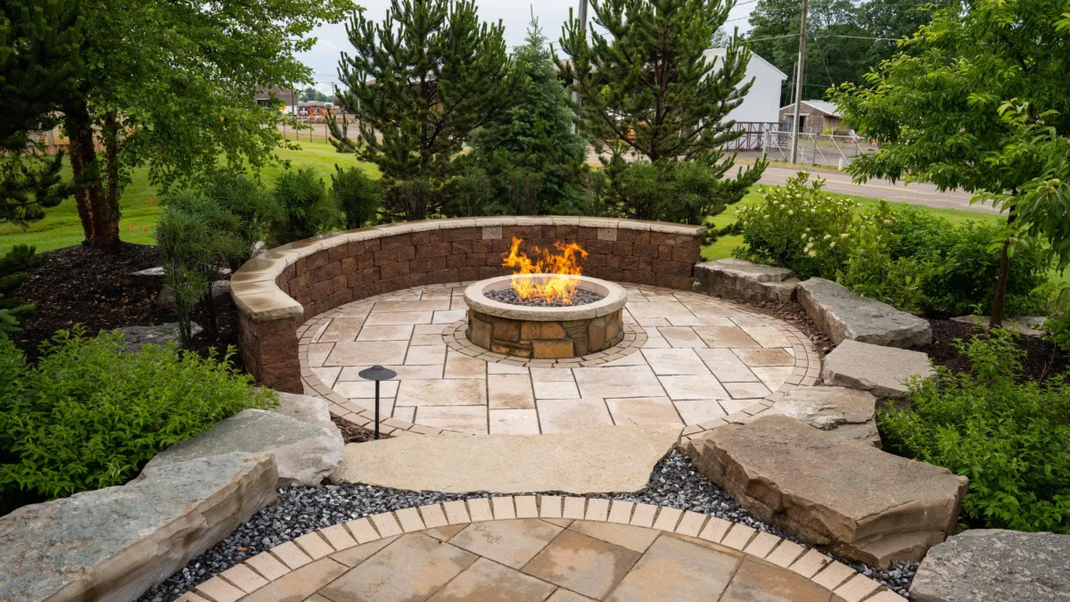 Circular paver patio with built-in fire pit surrounded by greenery — outdoor hardscape project by Mundo Landscaping Tucson, AZ.