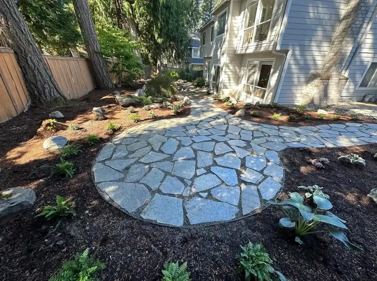 Circular natural flagstone patio with curved pathway, boulder accents, ferns, and hostas by HD Landscape in Lake Oswego