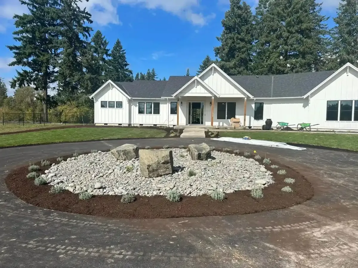 Circular driveway island with boulder accents, river rock, and lavender plantings by HD Landscape in Newberg