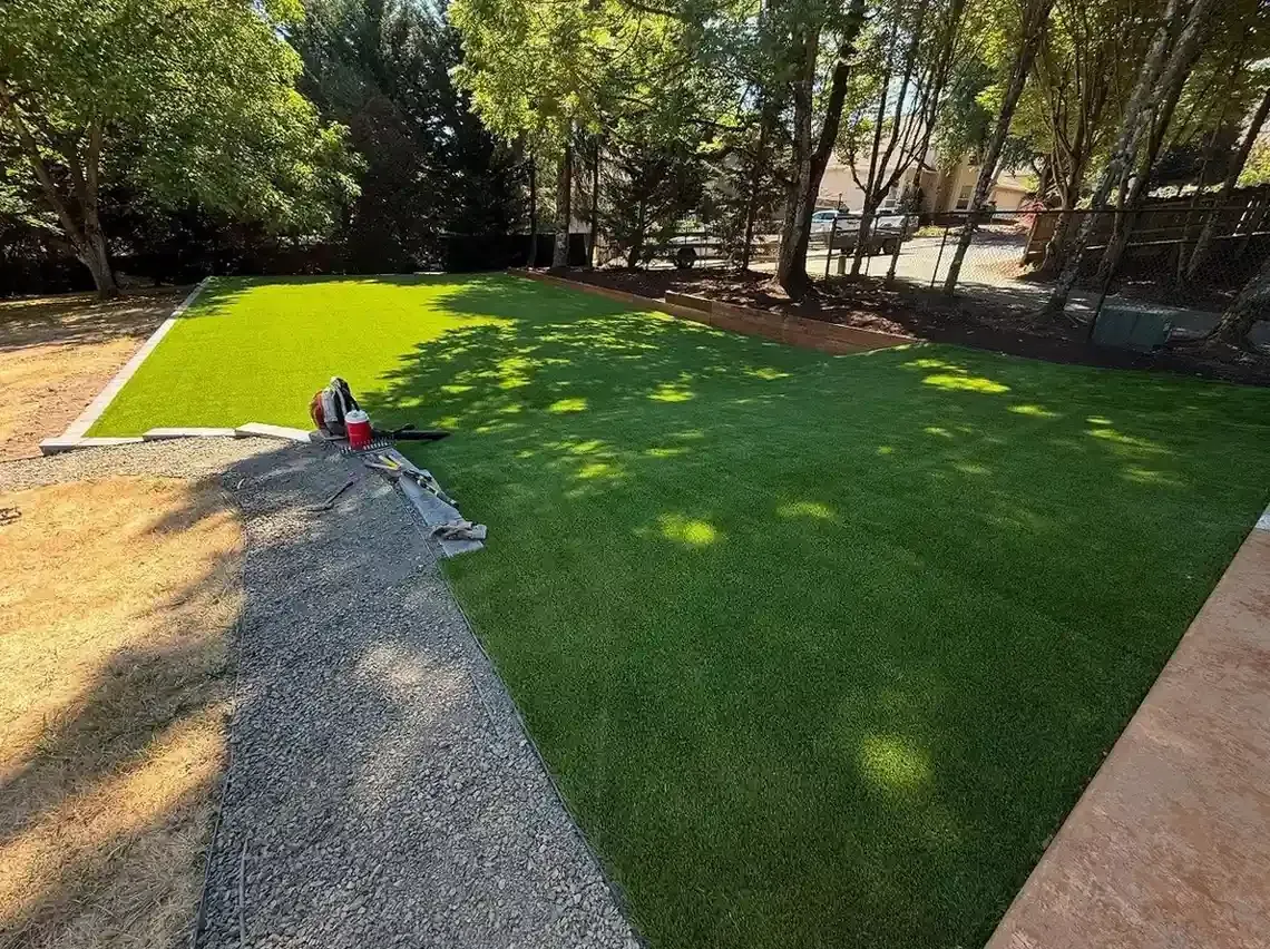 Large backyard sod installation with timber-edged planting beds and mature tree canopy by HD Landscape in Sherwood