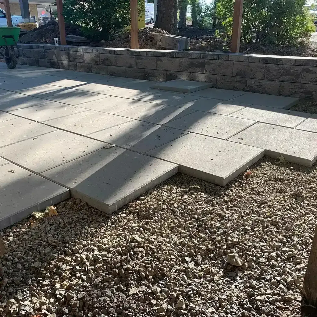 Large format concrete paver walkway installation with crushed gravel base and block retaining wall by HD Landscape in Portland