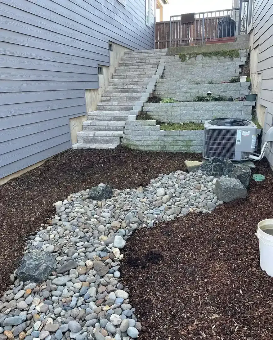 Block retaining wall with paver steps, river rock dry creek bed, and mulch planting area by HD Landscape in Beaverton
