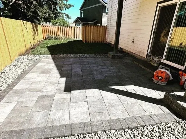 Two-tone paver patio with river rock border and lawn surround completed by HD Landscape in Sherwood