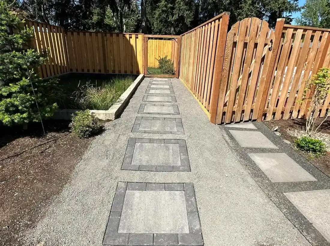 Bordered paver stepping stones through crushed gravel pathway with cedar gate and planting beds by HD Landscape in Portland