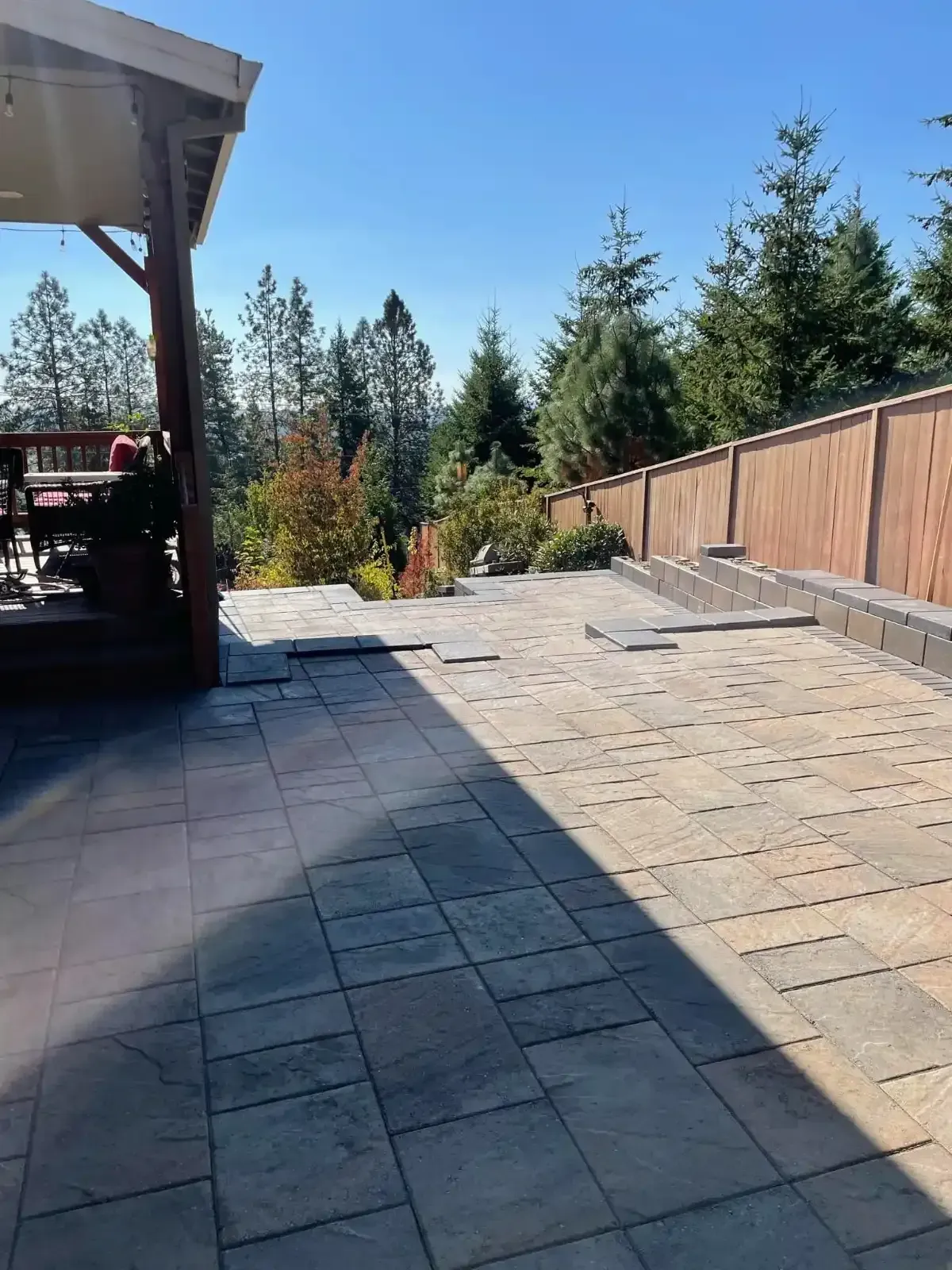 HD Landscape large format paver patio with pergola and staged seating wall in a wooded Newberg backyard