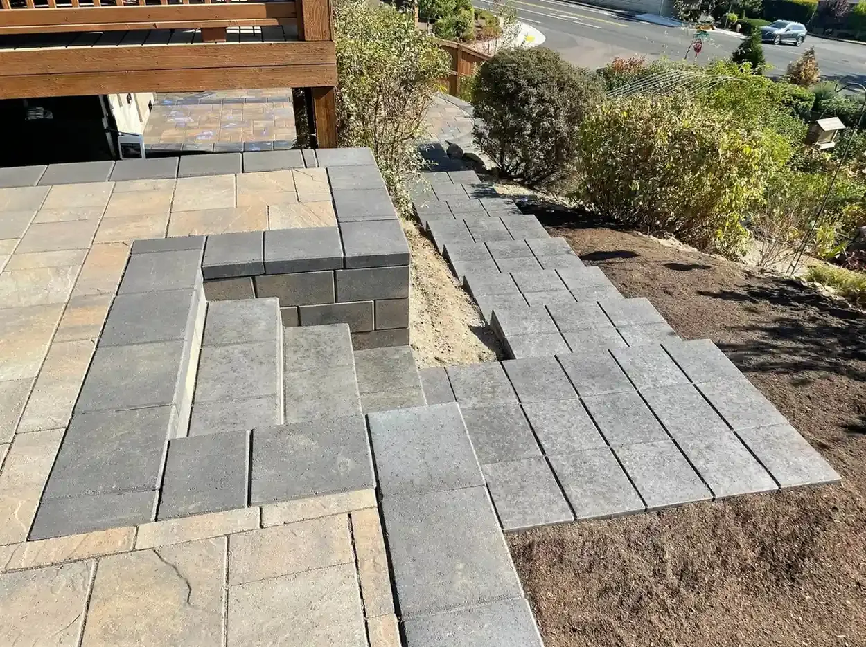Two-tone paver patio and sloped walkway installation in progress with block seating wall by HD Landscape in Lake Oswego