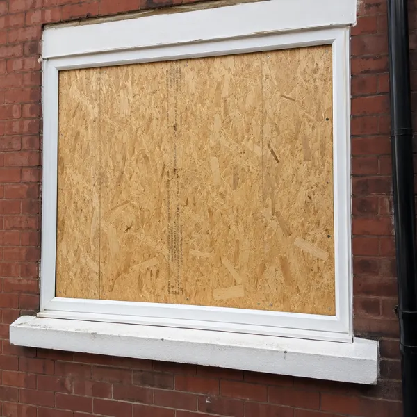 A boarded-up window on brick wall