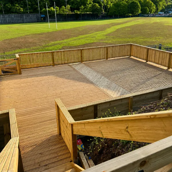 Wooden fencing and decking overlooking sports field in Caerphilly