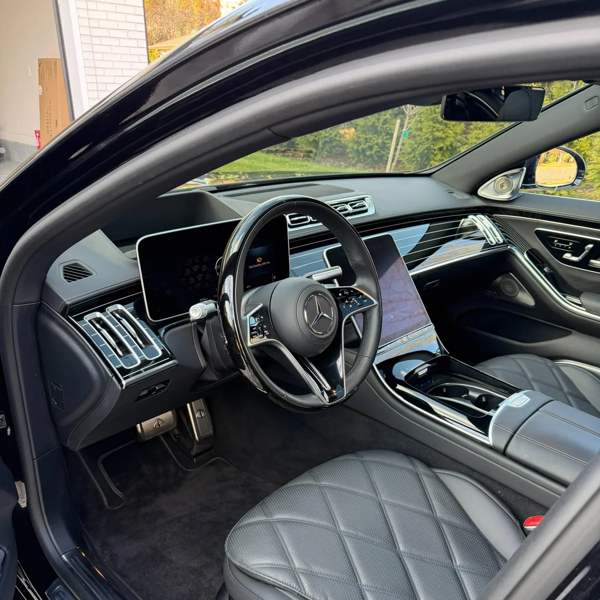 Detailer washing a car in a driveway