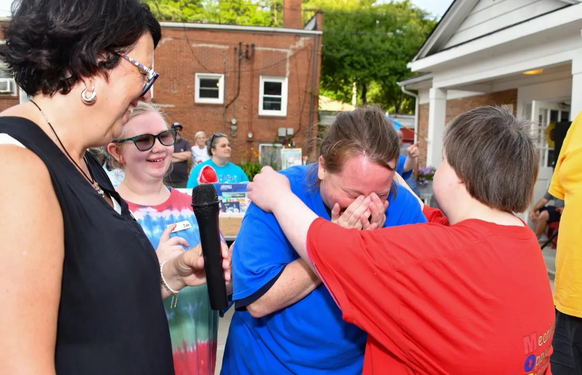 MORE Community members share an emotional moment of support and connection at an outdoor event.