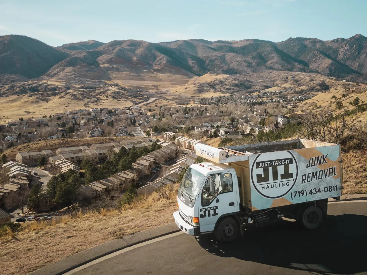 Just-Take-It Hauling's Isuzu NPR HD Dump Truck amidst the Colorado Rocky Mountains.