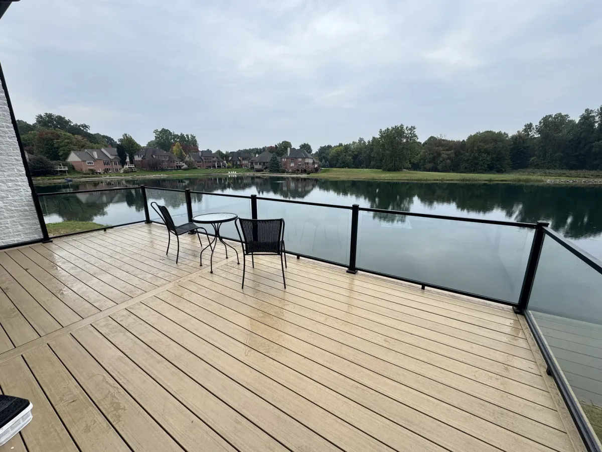 Finished lakeside deck with dark railings and a seating area