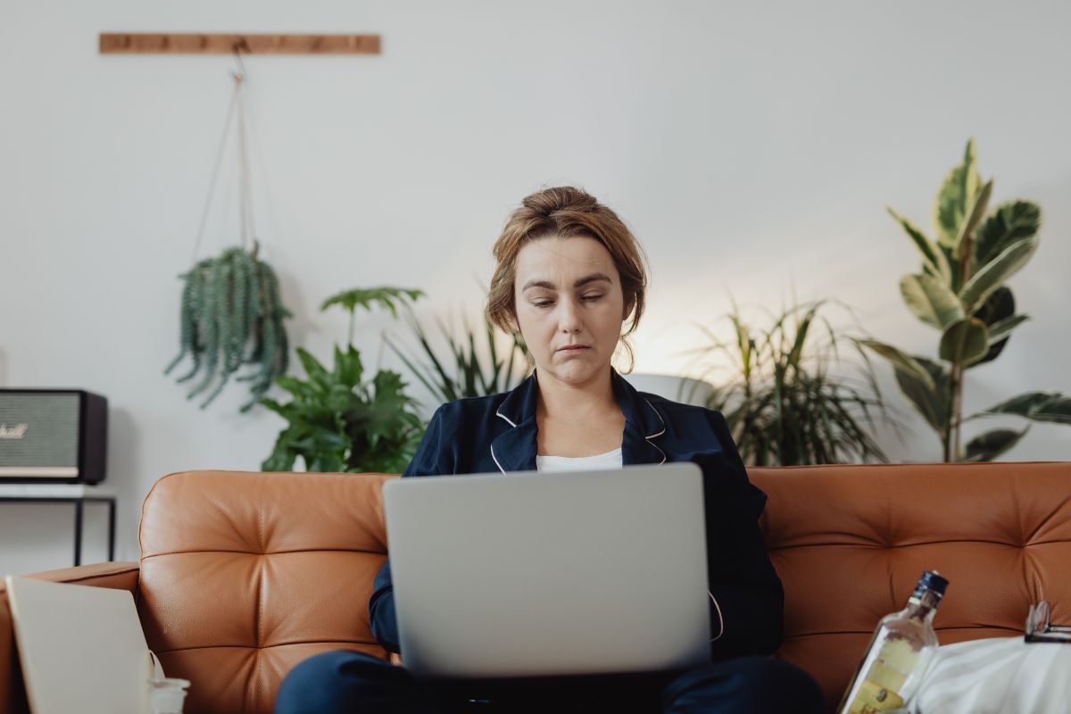 Woman using a laptop to plan funeral arrangements from home