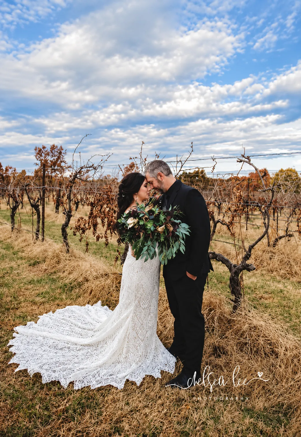 Scenic outdoor ceremony aisle framed with natural rustic floral installations