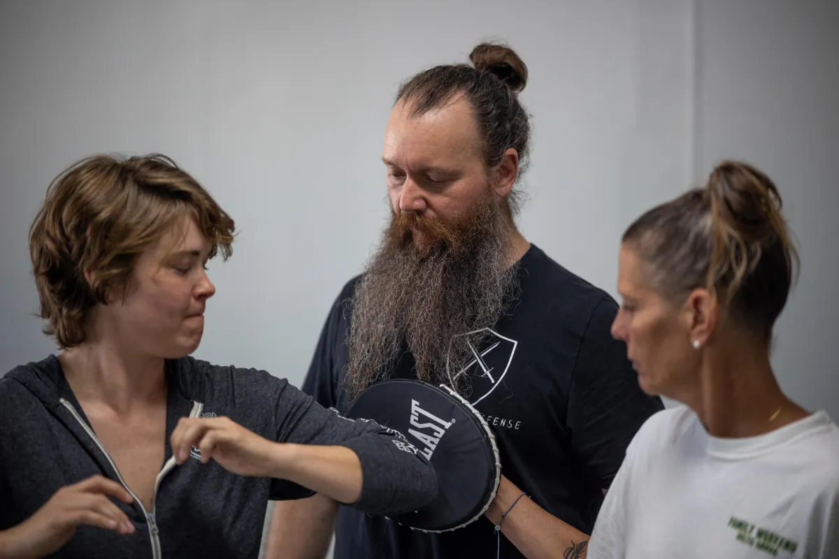 Self-defense instructor demonstrating technique with student