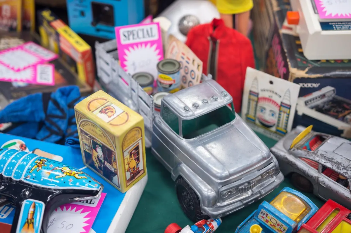 Silver toy truck on a table with cards and other toys