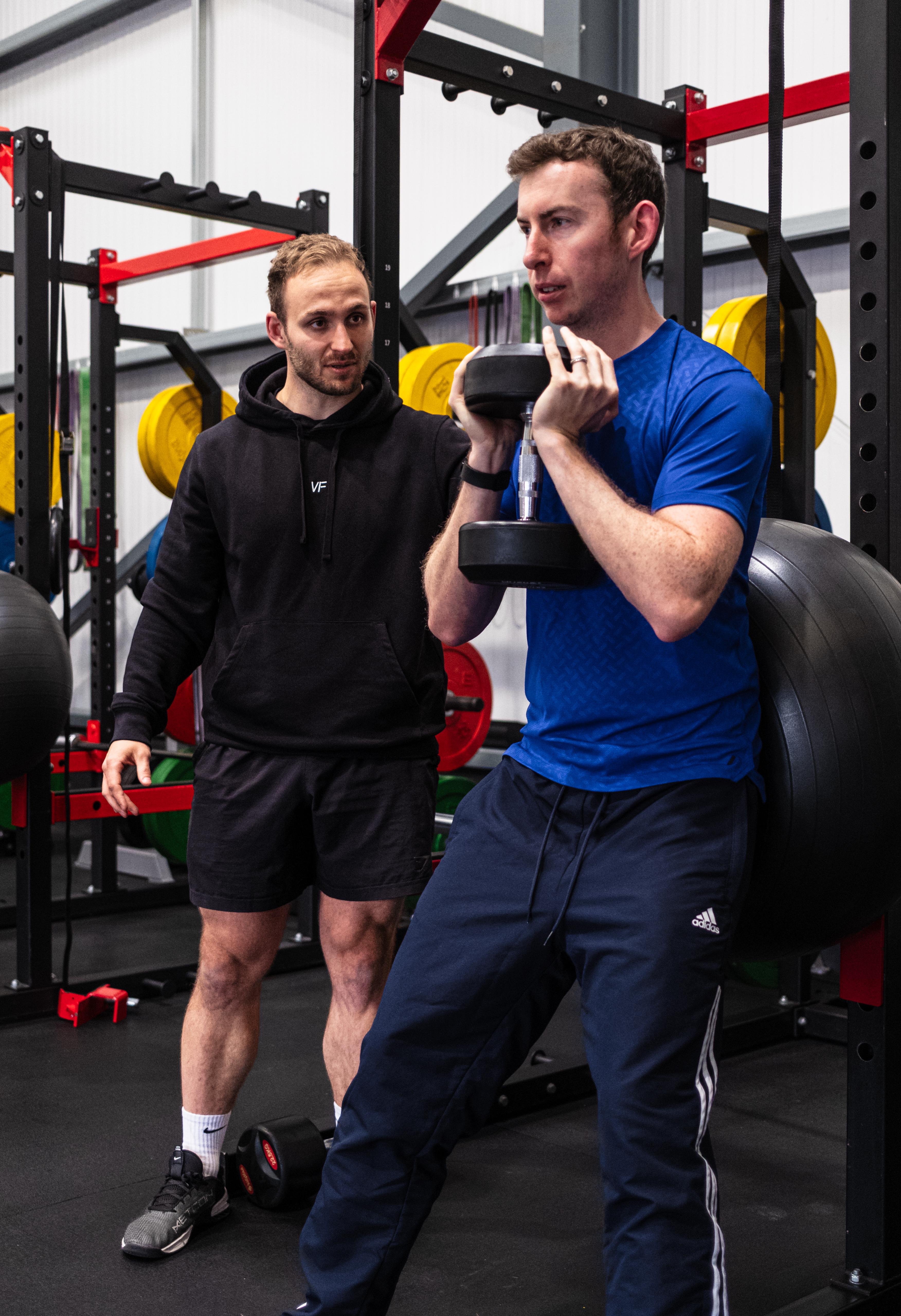 Silhouettes of people running along a waterfront at sunset.