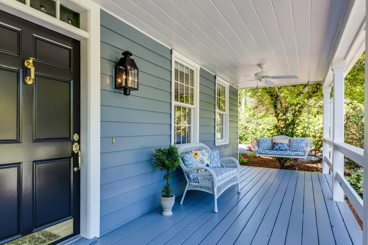 Sunlit front porch with chairs and plants symbolizing rest, welcome and reflection.