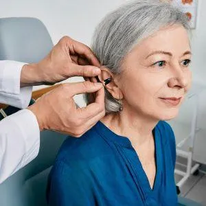 woman having hearing aid put in her ear