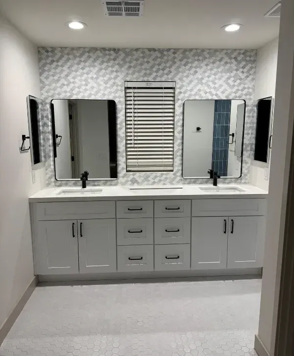 Double vanity bathroom remodel with custom cabinets, modern mirrors, and tiled flooring