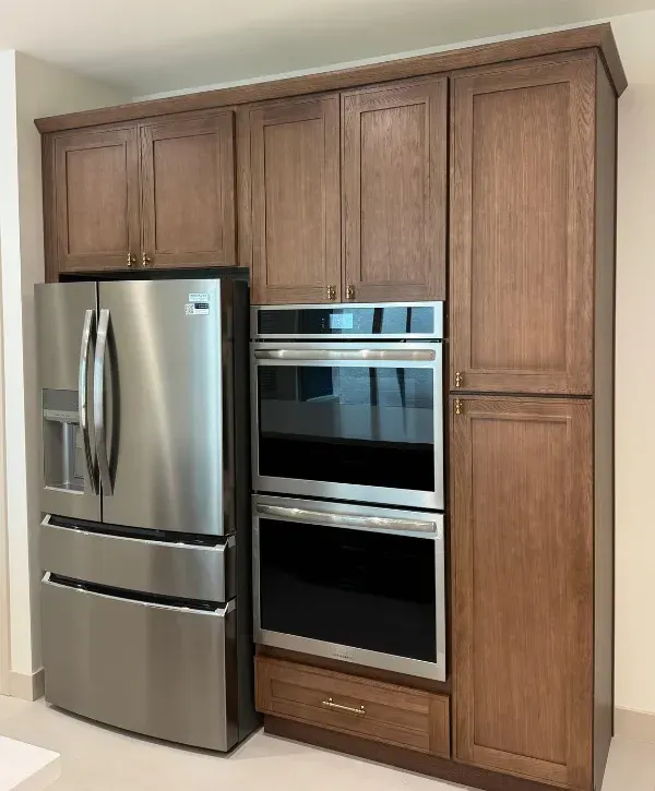 Built in kitchen cabinets with stainless steel refrigerator and wall ovens
